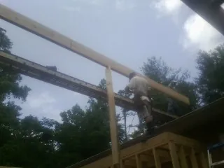Carpenter setting a ridge beam over a new addition frame — Ice Dam Removal by Roofing Brothers in Silver Spring