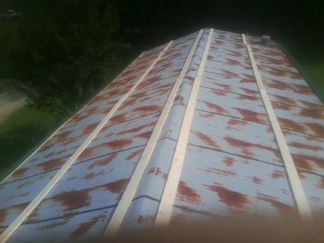Rusted metal roof panels with new wood purlins before replacement — Storm Damage Roof Repair in Silver Spring by Roofing Brothers
