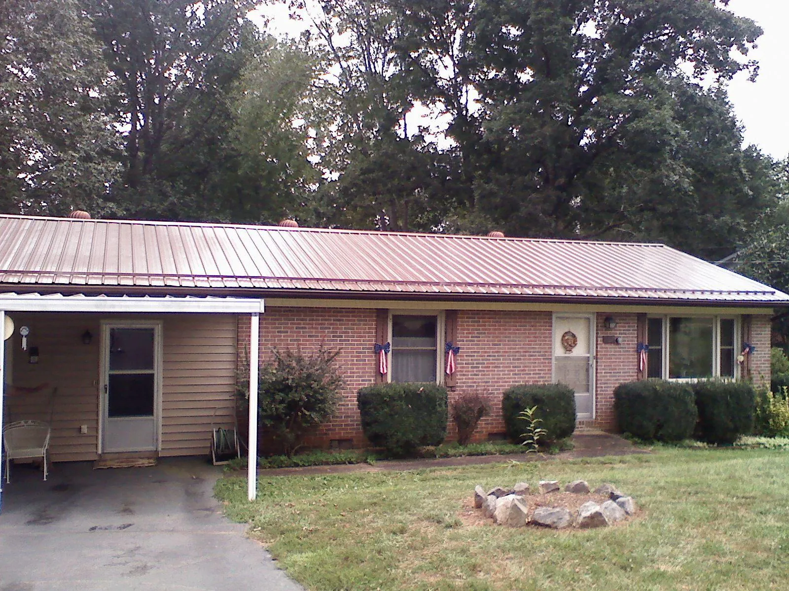 Bronze metal roof and carport on a brick ranch home — Roof Repair work by our crew in Silver Spring